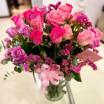 Jarrón con 24 rosas fucsia, lilas y estatil